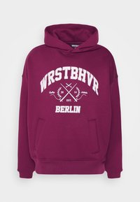 Bordeauxkleurige hoodie met witte grafische tekst "WRSTBHVR," "Berlijn," en ontwerp elementen. Klassieke pasvorm met een kangoeroe pocket en trekkoordcapuchon.