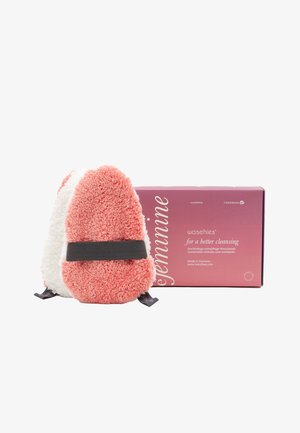 Coral and white plush reusable washpad with a black strap, packaged in a pink box labeled "for a better cleansing." Sustainable material.