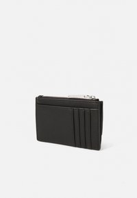 Portefeuille en cuir noir avec fermeture éclair, doté de plusieurs emplacements pour cartes et d'une texture lisse. Design rectangulaire compact. Accents en métal argenté.
