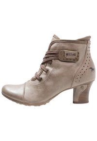 Béžová kotníčková bota s texturovaným koženým povrchem, hnědými tkaničkami a dřevěným podpatkem. Obsahuje kovové akcenty a logo Mustang na boku.