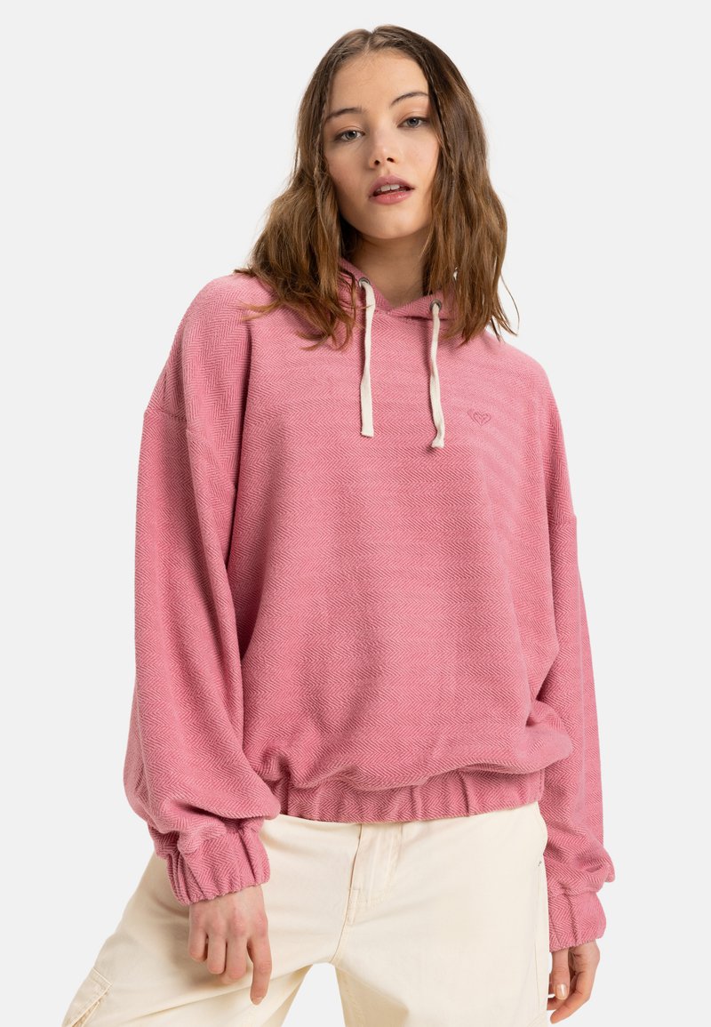 Pink hooded sweatshirt with herringbone texture, drawstrings, and elastic cuffs. Features a slight waistband and subtle logo detail.