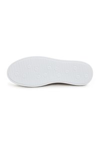 Semelle de chaussure blanche avec des motifs circulaires et une texture côtelée, vue par le dessous sur un fond blanc uni.