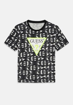 Črna bombažna majica s kratkimi rokavi, okroglim ovratnikom, ki prikazuje ponovljen vzorec in velik zeleni trikotnik z logotipom "GUESS" v beli barvi.