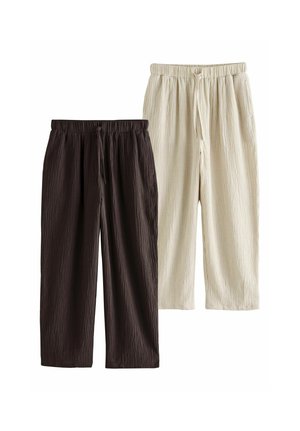 Deux pantalons en tissu froissé avec taille élastique et cordons, un marron foncé et un blanc cassé.