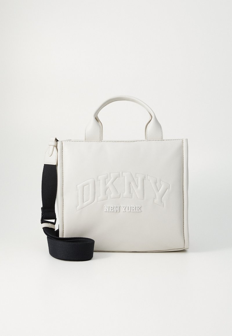 Weiße Leder-Tote-Tasche mit prägtem "DKNY NEW YORK"-Logo. Verfügt über kurze Griffe und einen abnehmbaren schwarzen Schultergurt. Rechteckige Form.