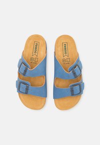 Sandales en cuir bleu avec deux boucles ajustables, une semelle intérieure en liège et une semelle texturée beige. Présente un logo sur la semelle intérieure et les sangles.