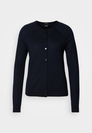 Marineblå cardigan lavet af blødt strikket stof med lange ærmer, rund hals og fuld knaplukning foran med matchende knapper.