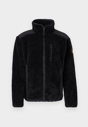Svart fleecejakke med en glatt svart øvre del, glidelås foran, glidelåslomma på brystet og en logo på skulderen. Mykt, strukturert materiale.