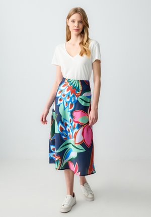 Gonna midi a fiori con colori vivaci come blu navy, rosa e verde, realizzata in tessuto leggero. Abbinata a una t-shirt bianca con scollo a V e sneakers.