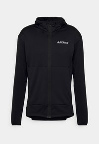 Felpa nera Terrex con zip completa, maniche lunghe e cappuccio regolabile. Realizzata in tessuto testurizzato e leggero, con logo sul petto.