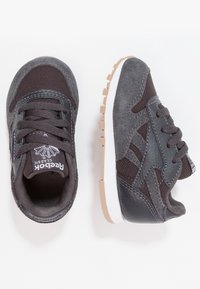 Szare buty sportowe wykonane z mieszanki zamszu i siateczki, z czarnymi akcentami i gumową podeszwą. Klasyczny fason na sznurowadła.