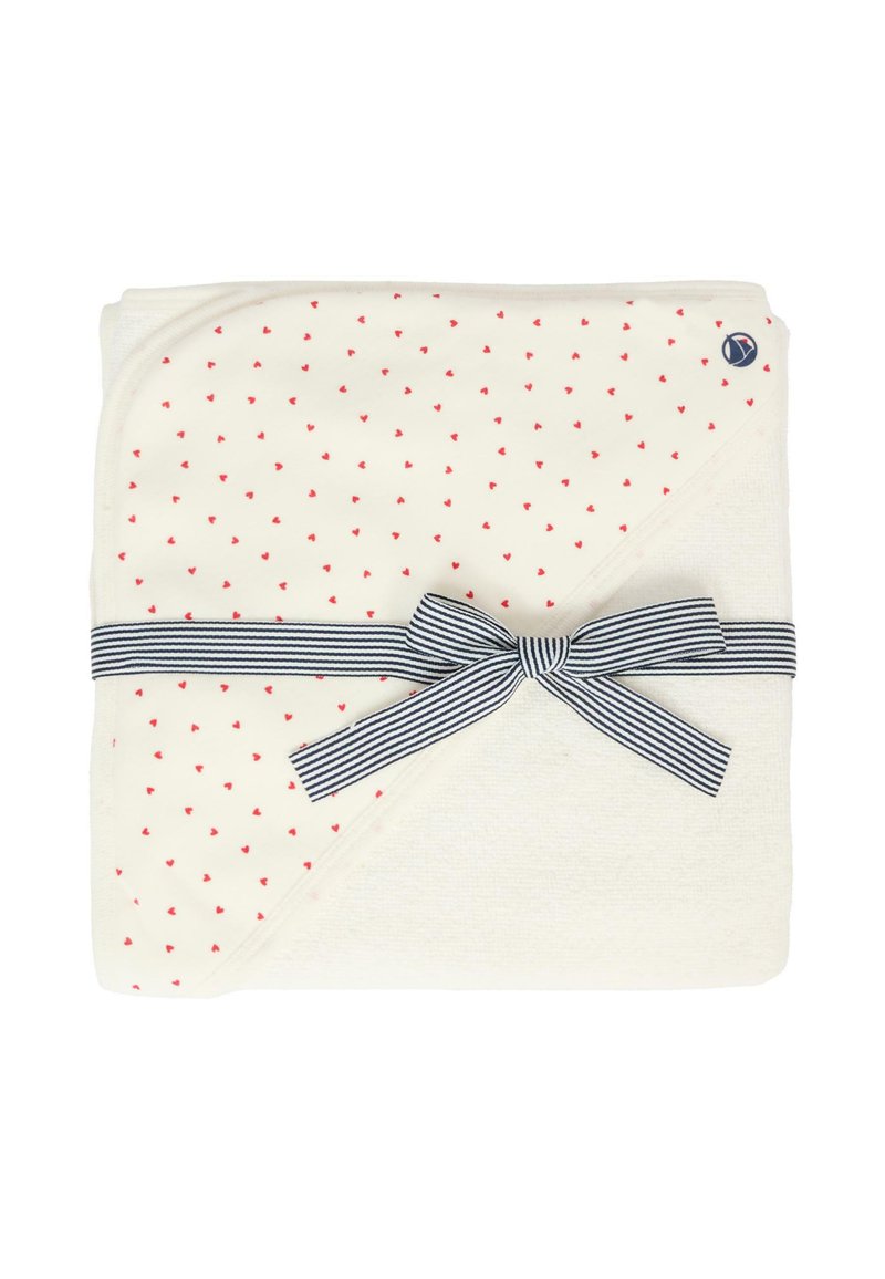 Coperta bianca con un motivo a cuori rosse, piegata con un nastro a righe blu. Presenta una texture morbida e angoli arrotondati.