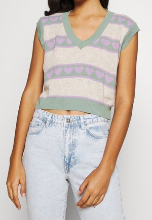 Gebreide mouwloze trui met een V-hals, voorzien van een lichtbeige basis, groene en lavendel hartpatronen en geribbelde accenten. Casual cropped pasvorm.
