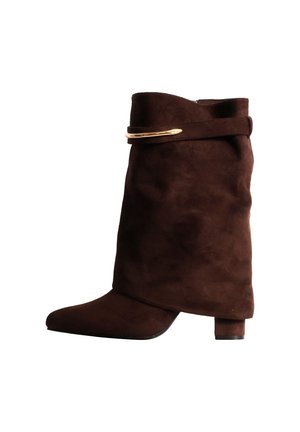 Botte montante en daim marron foncé, à bout pointu, talon bloc et détail de boucle dorée.