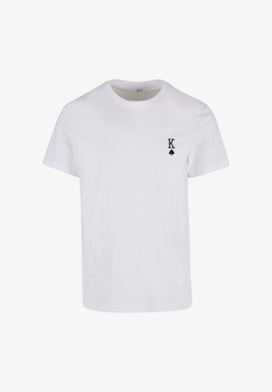 T-shirt en coton blanc à manches courtes, col rond, avec un logo noir en forme de "K" et de trèfle sur la poitrine gauche. Texture lisse.