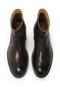 Botas de tobillo de cuero marrón oscuro con un acabado suave, punteras redondeadas y cremalleras laterales. El interior presenta un forro de cuero color marrón claro.