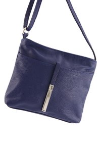 Kleine marineblau leren tas met een gestructureerde afwerking, voorzien van een voorvak en een zilverkleurige ritsaccent. Inclusief verstelbare schouderriem.