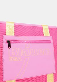 Roze mesh draagtas met gele accenten. Voorzien van een ritsvak en bedrukte "Blauer. USA" logo. Stevige hengsels voor gemakkelijk dragen.