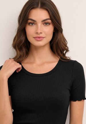 Melns ribots īsroku tops ar apaļu izgriezumu un viļņotām piedurkņu malām, izgatavots no mīksta, elastīga materiāla. Nav redzamu rakstu vai metāla detaļu.