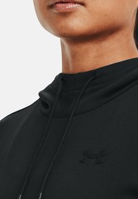 Czarna bluza z kapturem, wykonana z gładkiego materiału, z prążkowanym kapturem i sznurkami do ściągania, z delikatnie wytłoczonym logo na piersi.