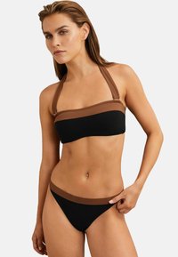 Juodas bikini rinkinys, turintis bandeau tipo viršutinę dalį su rudais akcentais ir reguliuojamomis petnešėlėmis; derantis aukštai iškirptas dugnas su lygiu paviršiumi.