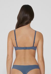 Modrý prádlo set s hladkou texturou, nastavitelnými ramínky a jednoduchým uzavíráním na háček. Zobrazeno z pohledu zezadu.