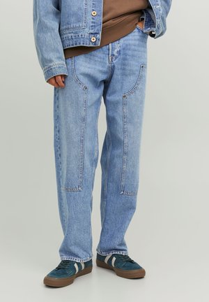 Lys blå denim jeans med en løs pasform, der har laplommer og kontrasterende syninger. Bæres med mørkeblå sneakers.