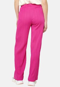 Roze wijd uitlopende broek van een gestructureerde stof met een ribbelpatroon, uitgerust met een elastische tailleband en een ontspannen pasvorm.
