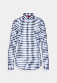 Camicia a maniche lunghe da uomo con pattern a quadri blu e bianchi e colletto appuntito su sfondo uniforme.