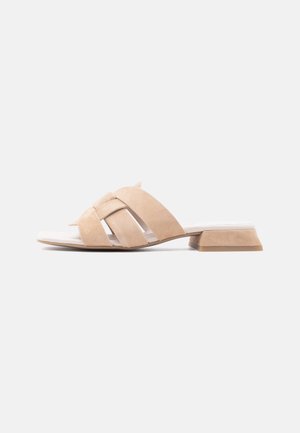 Beige åben tå slidesandal med tre brede krydsede stropper og lav blokhæl på hvid baggrund.
