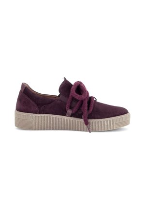 Lässiger Low-Top-Sneaker aus dunkelviolettem Wildleder mit dicker, strukturierter beiger Sohle und großen, weichen lilafarbenen Schnürsenkeln, die zu einer Schleife gebunden sind.
