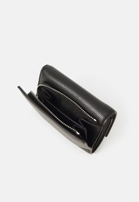 Portafoglio in pelle nera con finitura testurizzata, chiusura con zip e molteplici compartimenti, con una fodera interna in tessuto a contrasto.