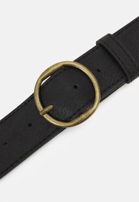 Ceinture en cuir noir dotée d'une boucle en laiton circulaire, avec une texture lisse et plusieurs trous d'ajustement sur un côté.
