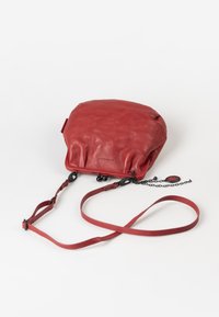 Rotte Lederschultertasche mit runder Form, weicher Textur, Ketten- und Riemenakzenten, die ein schlankes Design und minimale Hardware aufweist.