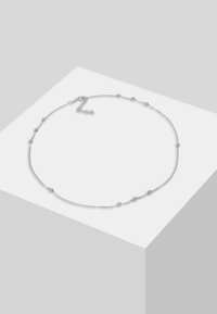 Silberne Kettenhalskette mit kleinen runden Perlen entlang der Kette, ausgestattet mit einem Karabinerverschluss und verstellbarer Länge. Glatte Metalloberfläche.