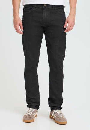 Zwarte denim jeans met een slim fit, vijf-pocket ontwerp, knoopsluiting en subtiele stikdetails. Gekocht met grijze suède sneakers.