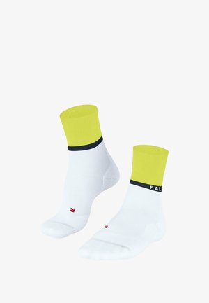 Chaussettes blanches avec des poignets jaunes et une rayure marine ; présentent un logo rouge. Fabriquées dans un textile lisse ; longueur courte au niveau de la cheville.