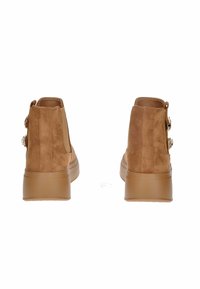 Stivaletti ankle in suede marrone con suola platform color tan. Presentano hardware decorativo sui lati e una texture liscia. Vista posteriore mostrata.