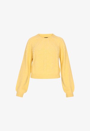 Keltainen lyhyt neulepusero pehmeästä materiaalista, pitkät hihat, jossa on teksturoitu pinta ja koristeltuna pienillä valkoisilla helmillä.