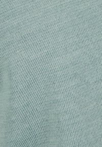 Tessuto lavorato a maglia di colore azzurro chiaro con una consistenza fine e liscia. Variazioni sottili di tonalità creano un aspetto morbido ed omogeneo.