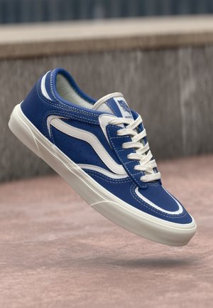 Blue sneaker with white accents, leather and mesh upper, rounded toe, and flat white laces. Features perforations for ventilation and logo.