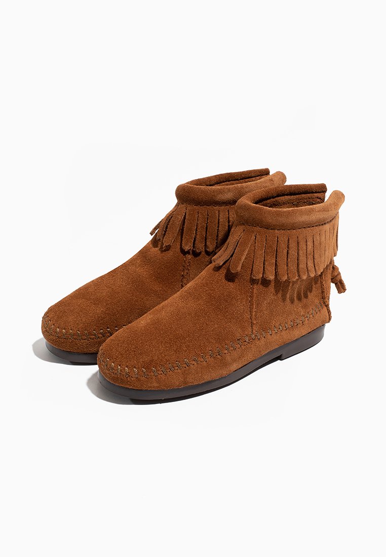 Botines de ante marrón con detalles de flecos y costuras decorativas, con una suela plana y una textura suave.