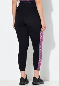 Zwarte legging met een nauwsluitend ontwerp, voorzien van een geprint paarse zijpaneel en contrasterende stiksels; textuur, rekbare stof; enkel lengte.