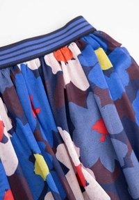 Spódnica w kwiatowy wzór z niebieskim, czerwonym i żółtym motywem. Wykonana z miękkiego materiału, z ciemnoniebieskim elastycznym pasem w paski.