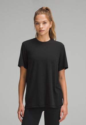 Zwarte T-shirt met korte mouwen, ronde hals en een ontspannen pasvorm. Zachte, gladde stof; minimalistisch ontwerp zonder zichtbare patronen of accenten.