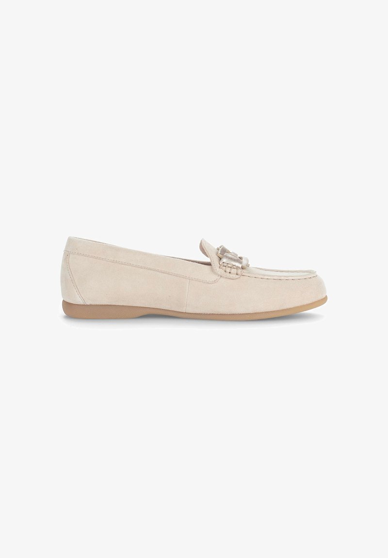 Mocasín de mujer de ante beige con suela baja de goma y detalle decorativo de flecos en la parte superior, mostrado de perfil lateral sobre fondo blanco.