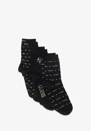 Quattro paia di calzini neri con vari design, tra cui stampe di logo e motivi, con accenti color oro e una texture morbida.
