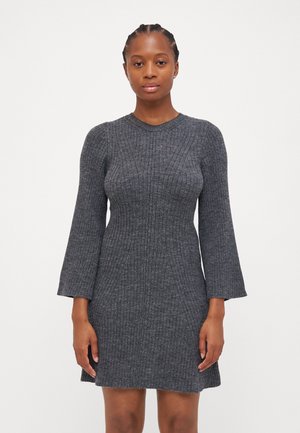 Robe en tricot côtelé gris avec un corsage ajusté, des manches longues évasées et un col rond, présentant des lignes texturées et une encolure légèrement évasée.