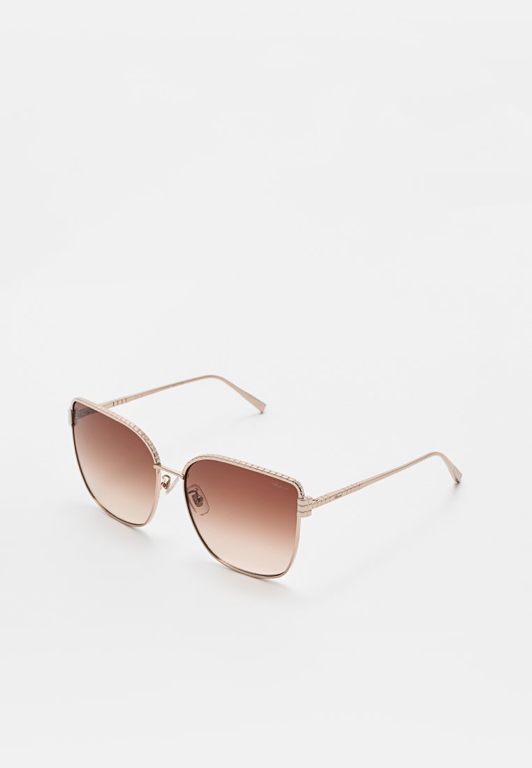Bruine gradient zonnebril met een vierkante vorm, roségouden metalen frame en textuur aan de zijkanten. De glazen zijn oversized met dikkere bovenranden.