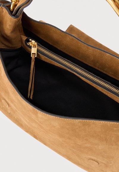 Καφέ τσάντα χειρός από σουέντ με ανοιχτό πάνω μέρος που αποκαλύπτει μαύρο υφασμάτινο εσωτερικό και χρυσή τσέπη με φερμουάρ και τράβηγμα από σουέντ.